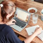 woman sitting at dinning table with laptop